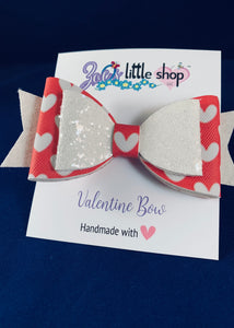 Valentine’s Day themed 4 inch faux leather bow in pink and white glitter.