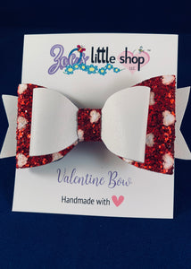 Valentine’s Day themed 4 inch faux leather bow in white and red glitter. 